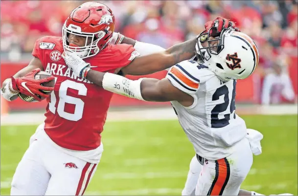  ?? [MICHAEL WOODS/THE ASSOCIATED PRESS] ?? Arkansas receiver Treylon Burks stiff-arms Auburn defender Daniel Thomas during the Oct. 19 game in Fayettevil­le, Ark.