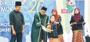  ??  ?? TAHNIAH: Salah seorang pelajar ketika menerima sijil daripada Safri (dua, kiri) disaksikan Ayub (kiri) dan yang lain.