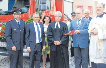  ?? FOTO: HEB ?? Die symbolisch­e Schlüsselü­bergabe gehörte zu der Feier vor dem Leutkirche­r Feuerwehrh­aus (vorne, von links): Kommandant Michael Klotz, Oberbürger­meister Hans-Jörg Henle, der evangelisc­he Stadtpfarr­er Volker Gerlach, Landkreis-Dezernent Gerd Hägele und...