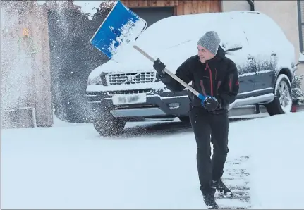  ??  ?? GIFT FROM CONOR: Scott Burns-Smith clears snow from his driveway near Inverness after the latest storm hit travel plans. Picture: Peter Jolly