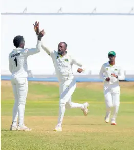  ?? PHOTO BY LENNOX ALDRED ?? Windward Islands Volcanoes seamer Ryan John (right) celebrates with captain Kimani Melius after picking up one of his five wickets on the opening day of the West Indies Championsh­ip match against the Jamaica Scorpions at Sabina Park yesterday.