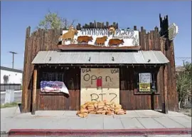  ?? Dania Maxwell Los Angeles Times ?? SANDBAGS AND PLYWOOD block the entrance to Tinhorn Flats, a Burbank restaurant that for months has refused to follow health orders from L.A. County.