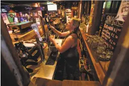  ??  ?? es its regulars, including Bella in the center seat; Smiley’s Schooner Saloon in ynn Lesser pours a beer at Smiley’s; at Old Western Saloon, the original which is perhaps best known for Prince Charles’ visit in 2005.