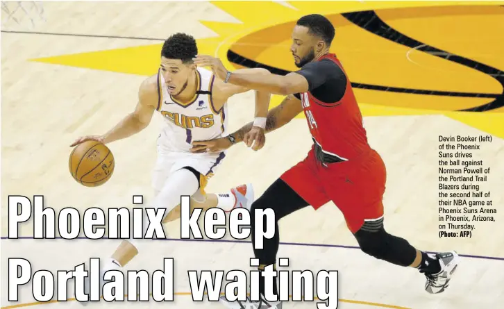  ?? (Photo: AFP) ?? Devin Booker (left) of the Phoenix
Suns drives the ball against Norman Powell of the Portland Trail Blazers during the second half of their NBA game at Phoenix Suns Arena in Phoenix, Arizona, on Thursday.