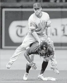  ?? Brian Blanco Getty Images ?? ANGELS SECOND BASEMAN Nolan Fontana leaps over Tampa Bay’s Michael Martinez during a fifth-inning double play.