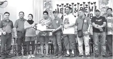  ??  ?? Arunarnsin (centre) presenting prizes to mixed doubles winners Yusri and Suriani, while Ajahar (4th right) and others look on.