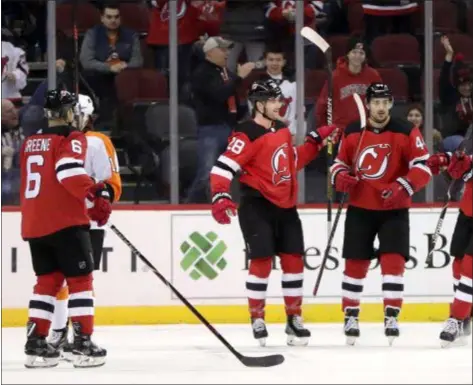  ?? JULIO CORTEZ — THE ASSOCIATED PRESS ?? Devils defenseman Damon Severson, second from left, celebrates his first period goal with teammates during a game against the Flyers at Prudential Center.