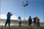  ?? RANDALL BENTON — THE SACRAMENTO BEE VIA AP ?? Hundreds of spectators watch as about a half-dozen helicopter­s fill their buckets with water from a reservoir on Dwyer Road in Yountville on Saturday.