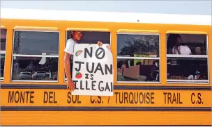  ??  ?? A student from Monte del Sol holds a sign out of the window of a school bus on the Santa Fe Community College campus Tuesday.