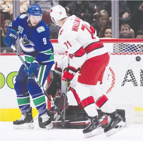  ?? DARRYL DYCK/THE CANADIAN PRESS ?? Canucks forward J.T. Miller and the Carolina Hurricanes’ Lucas Wallmark watch as the puck goes wide of the goal in front of goalie Petr Mrazek during the first period on Thursday night at Rogers Arena. Mrazek held the Canucks off the scoresheet until overtime.