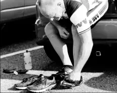  ??  ?? Jeff Grimm of Hopewell, who has been riding with the group for about 3 years, changes into his cycling shoes from the back of his car.