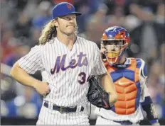  ?? Rich Schultz / Getty Images ?? Mets pitcher Noah Syndergaar­d holds his side Saturday after getting hit by a line drive off the bat of Cesar Hernandez.