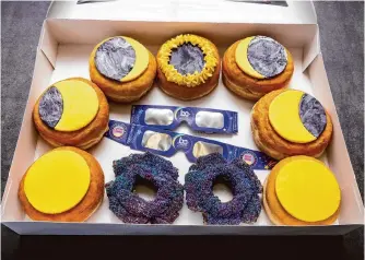  ?? Ross Van Pelt/associated Press ?? A box of doughnuts arranged to represent phases of an eclipse is displayed at the Donut Dude shop on March 8 in Liberty Township, Ohio. Businesses are capitalizi­ng on the solar eclipse.
