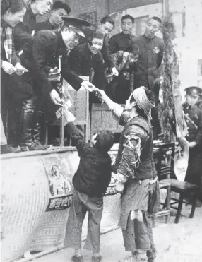  ??  ?? 1940年重庆春礼劳­军募捐活动中，两名乞丐到献金台捐款