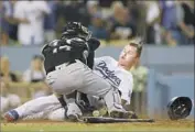 ?? Luis Sinco ?? JOC PEDERSON scores in the fourth inning as Colorado catcher Tony Wolters loses control of the ball.