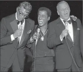  ??  ?? Frank Sinatra (right) sings along with fellow “Rat Pack” members Dean Martin (left) and Sammy Davis Jr. at a fundraisin­g event in 1978 in Santa Monica, Calif.