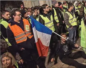  ??  ?? Des « gilets jaunes » devant l’hôtel de ville de Pau, samedi.