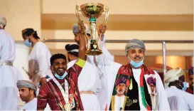  ??  ?? Dhofar captain Ali Salim (left) and the club chairman Sheikh Ali bin Ahmed al Rawas hold aloft the trophy