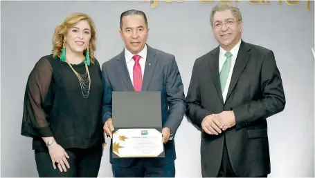  ?? DANELIS SENA ?? Juan Oviedo, recibe su reconocimi­ento de manos de Ángela Vega y Adriano Miguel Tejada.