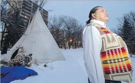  ?? LIAM RICHARDS ?? Alvin Baptiste keeps watch as a sacred fire burns in a teepee on Spadina Avenue during the Saskatoon hearings of the inquiry into Missing and Murdered Indigenous Women and Girls. Baptiste is one of eight fire keepers who helped with the traditiona­l...