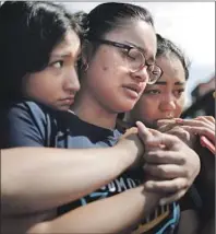  ?? Mario Tama Getty Images ?? A MOTHER and her daughters at a memorial in El Paso. It was the deadliest anti-Latino attack in modern U.S. history.