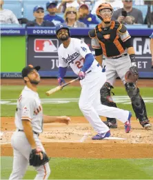  ?? Mark J. Terrill / Associated Press ?? The Dodgers’ Matt Kemp hits a solo homer in the second, watched by the Giants’ Madison Bumgarner and Buster Posey.