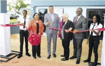  ?? ?? Prime Minister Andrew Holness (third left); Chair of Digicel Foundation Jean Lowrie-chin (second left); Sisters of Mercy Area Coordinato­r Susan Frazer (third right); and Manchester Custos Garfield Green (second right) and students Leoni Wisdom (right) Russhad Buchanan participat­e in the ribbon cutting for the official opening the St John Bosco Vocational Training Centre in Hatfield, Manchester, last Wednesday.