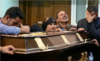  ?? AFP ?? Egyptian relatives and friends of Assad Labib, 35, an attack victim, react during his funeral at the Anglican church in Sawaada village near Minya city on Saturday. —