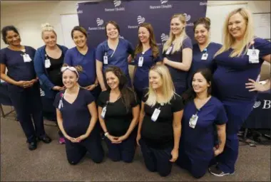  ?? ROSS D. FRANKLIN — THE ASSOCIATED PRESS ?? Most of the sixteen pregnant nurses who work together in the intensive care unit at Banner Desert Medical Center pose for a group photograph after attending a news conference where they all talked about being pregnant at the same time, with most of them due to give birth between October and January, Friday in Mesa, Ariz.