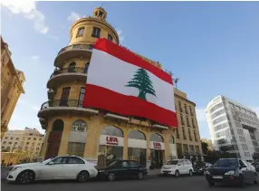  ??  ?? A LEBANESE FLAG hangs from a building in downtown Beirut yesterday.