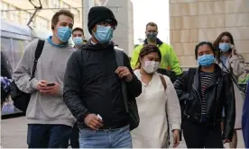  ?? Photograph: Loren Elliott/Reuters ?? Face masks are back in Sydney and surrounds as the Delta Covid variant takes hold, but the delay in mandating the measure may have contribute­d to the spread of the disease.