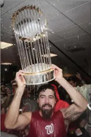  ?? DAVID J. PHILLIP — THE ASSOCIATED PRESS ?? Nationals third baseman Anthony Rendon celebrates with the trophy in the locker room after Game 7 of the World Series against the Astros on Oct. 30 in Houston.