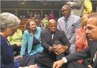  ?? REP. ELIZABETH ESTY’S OFFICE VIA AGENCE FRANCE-PRESSE ?? Rep. Elizabeth Esty, second from left, with Rep. John Lewis, center, and other members of Congress stage a sit-in on Wednesday. “I wondered, what would bring this body to take action?” thundered Lewis, who spoke at the lectern.