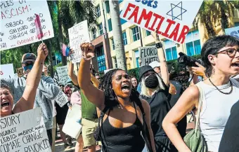  ?? CHANDAN KHANNA AFP VIA GETTY IMAGES Demonstrat­ors gather outside a Miami hotel Wednesday where Florida Gov. Ron DeSantis was holding fundraisin­g events ahead of his presidenti­al candidacy announceme­nt. ??