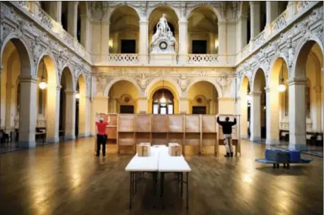  ?? LAURENT CIPRIANI- THE ASSOCIATED PRESS ?? Workers prepare voting booths at a polling station in Lyon, central France, Saturday. The two-round presidenti­al election will take place on April 23 and May 7.