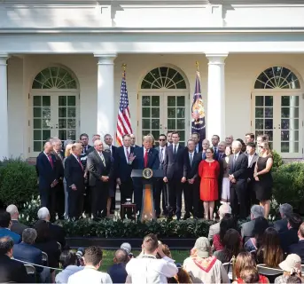  ?? White House Photo ?? President Donald J. Trump, joined by Cabinet members, legislator­s and senior White House advisers, announces completion of the United States-Mexico-Canada Agreement October 1, 2018, during a press conference in the Rose Garden of the White House.