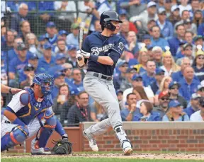  ??  ?? Brewers outfielder Christian Yelich hits an RBI single against the Cubs in the NL Central tiebreaker game Monday in Chicago. PATRICK GORSKI/USA TODAY