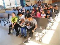  ?? Photo by Ernest A. Brown ?? Damien Glassey, Travis Bell, Raylenn Bello, and Adriel Fernandez, in front row from left, enjoy their new books with other second- and third-graders at Globe Park Elementary School Thursday morning. Six thousand books were donated by Ocean State Job...