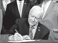  ?? AP/ANDREW HARNIK ?? Sen. Orrin Hatch, chairman of the Senate Finance Committee, signs the final version of the Republican tax bill Thursday during a ceremony at the Capitol.