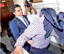  ??  ?? Ex-DBKL deputy director Sabudin Mohd Salleh attempts to avoid cameramen after his hearing at the KL Sessions Court yesterday.