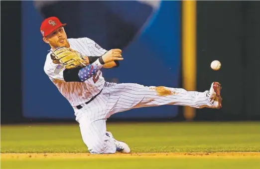  ??  ?? Rockies shortstop Trevor Story throws from a knee for the second out of the ninth inning against San Francisco s on Tuesday night.