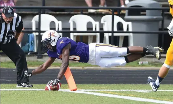  ?? MATHEW MCCARTHY, RECORD STAFF ?? Wilfrid Laurier’s Kurleigh Gittens Jr. dives just over the goal-line for a touchdown against Queen’s University Sunday in OUA football action at University Stadium in their season-opener.