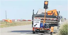  ?? MINISTRY OF HIGHWAYS AND INFRASTRUC­TURE ?? An Automated Flagger Assistance Device is operated remotely by a flag person at the side of the road.