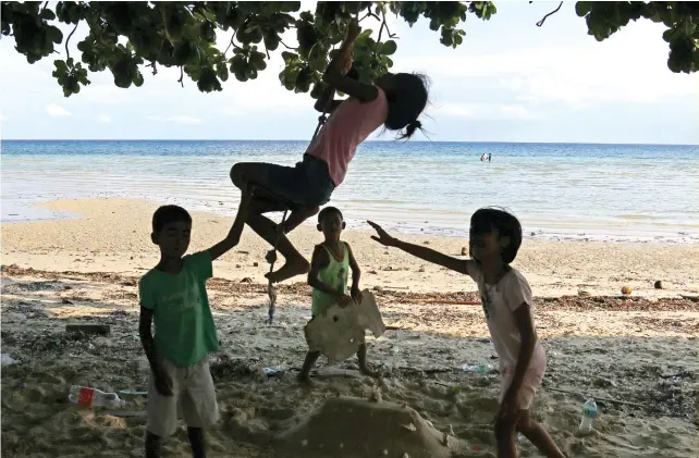  ??  ?? ISLAND LIFE: Children play on a makeshift swing with the beautiful beach of Santiago Bay, San Francisco in Camotes Island, Cebu and the sky and sea as their backdrop. PHOTO BY ALEX BADAYOS