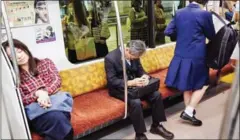  ?? KO SASAKI/THE NEW YORK TIMES ?? Commuters sleep on a train in Tokyo in October.