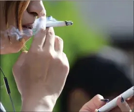  ?? PHOTO: BLOOMBERG ?? A woman relaxes with a cigarette in a designated smoking area. Is she smoking a tax-paying brand?