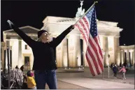  ?? Markus Schreiber / Associated Press ?? Marianne Hoenow from Connecticu­t celebrates the victory of President- elect Joe Biden and Vice President- elect Kamala Harris in front of the Brandenbug Gate next to the U. S. embassy in Berlin, Germany, Saturday.