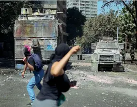  ?? (Getty Images) ?? In piazza Manifestan­ti in piazza a Santiago lanciano sassi contro i blindati