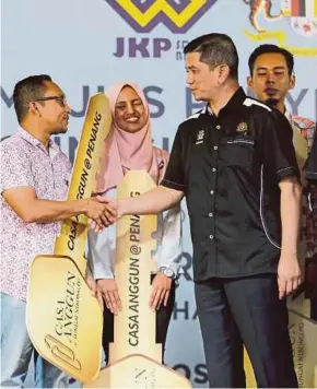  ?? (Foto Ramdzan Masiam/bh) ?? Mohamed Azmin (kanan) beramah mesra dengan penerima kunci rumah pada majlis penyerahan kunci Casa Anggun, Sungai Nibong, semalam.