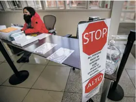  ?? ?? COVID-19 screener Veronica Carrillo waits to question people last month as they arrive at District Court. Pandemic protocols in New Mexico’s court system prompt continued discomfort, complaint and concern